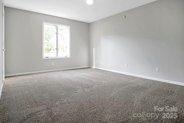 carpeted empty room with baseboards