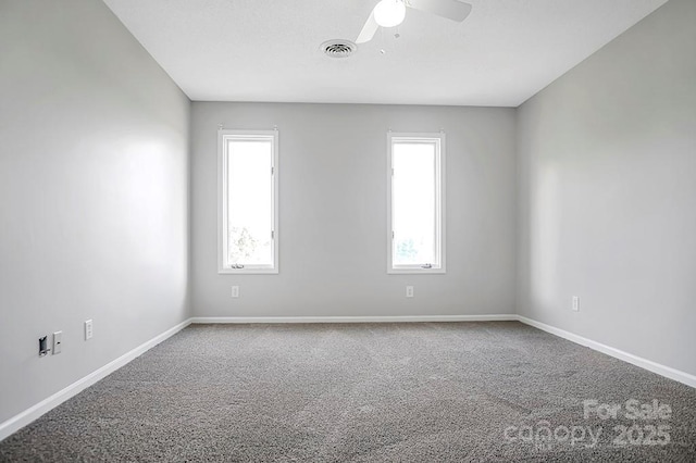 carpeted empty room with ceiling fan, visible vents, and baseboards