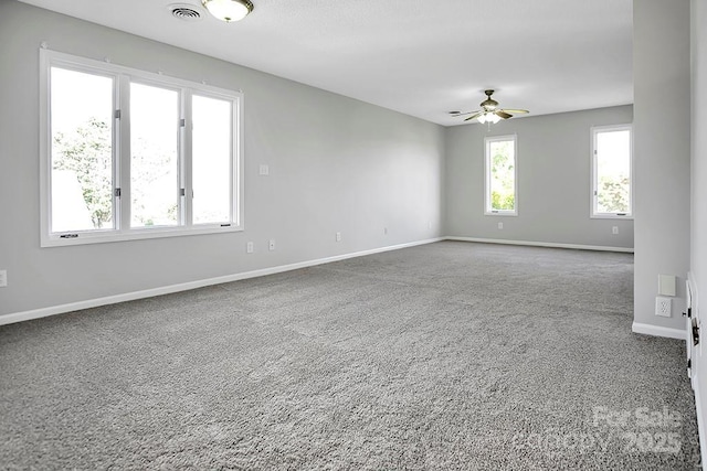 empty room featuring a ceiling fan, carpet, visible vents, and baseboards