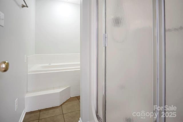 full bathroom with a shower stall, a bath, and tile patterned floors