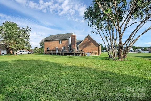 back of house with a deck, a yard, and brick siding