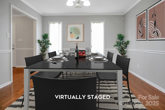 dining area featuring baseboards, ornamental molding, and wood finished floors