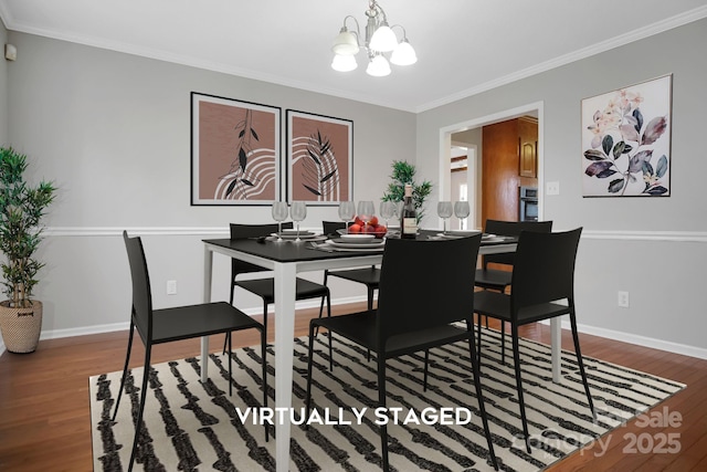 dining room with ornamental molding, wood finished floors, and a notable chandelier