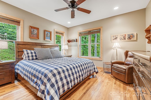 bedroom with multiple windows, ceiling fan, and light hardwood / wood-style floors