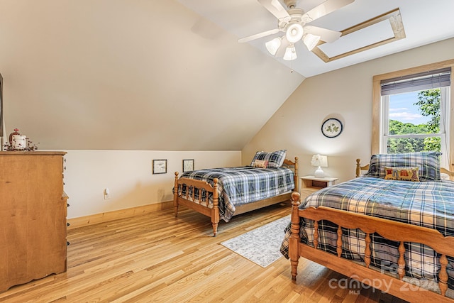 bedroom featuring ceiling fan, light hardwood / wood-style floors, and vaulted ceiling