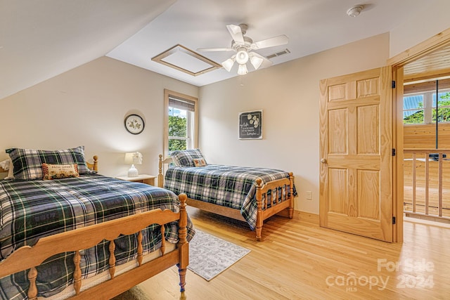 bedroom featuring ceiling fan, light wood-type flooring, and vaulted ceiling