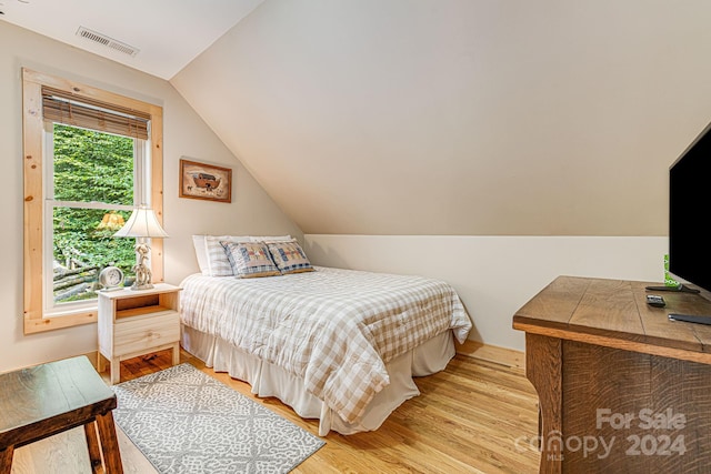 bedroom with lofted ceiling and light wood-type flooring