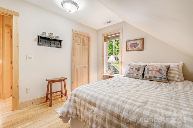 bedroom with light hardwood / wood-style floors and vaulted ceiling