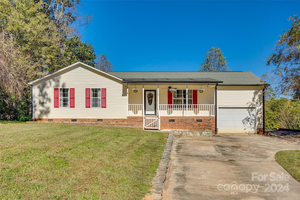 single story home with a front lawn, covered porch, and a garage