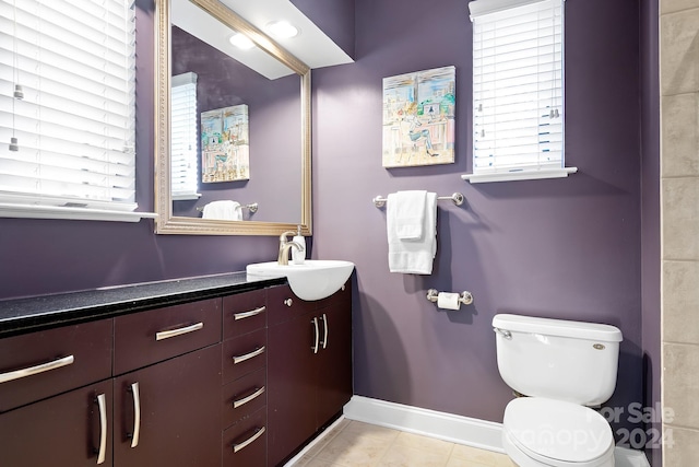 bathroom with vanity, toilet, and tile patterned floors