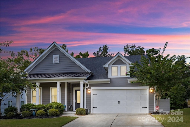 view of front of home with covered porch and a garage