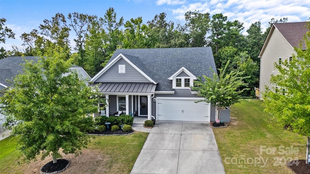 view of front of property featuring a porch, a garage, and a front yard