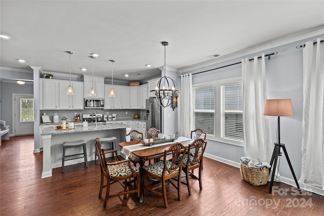 dining area with dark hardwood / wood-style flooring, sink, a chandelier, and crown molding