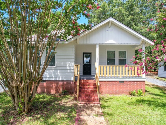 bungalow-style house with a porch and a front yard