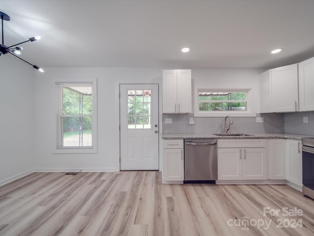 kitchen with sink, light wood-type flooring, decorative backsplash, and stainless steel appliances