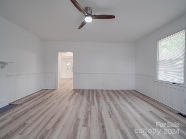 empty room with ceiling fan and light wood-type flooring