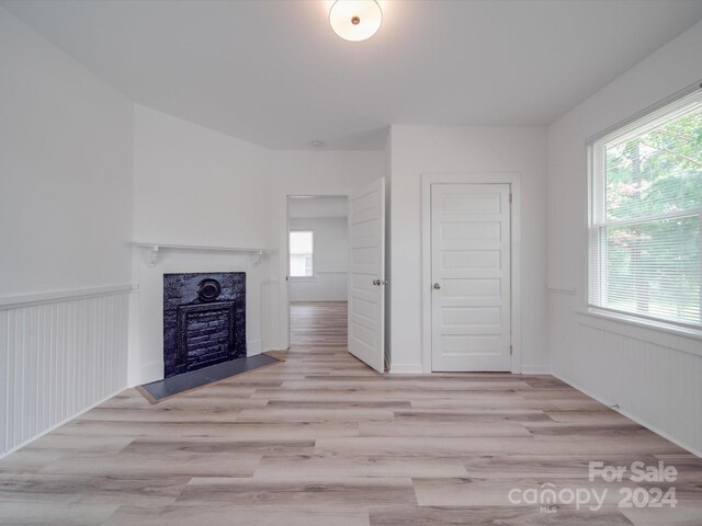 unfurnished living room with light wood-type flooring and a premium fireplace