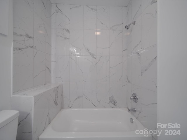 bathroom with tiled shower / bath and toilet