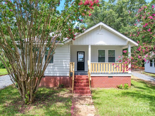 bungalow-style home featuring a front yard and covered porch