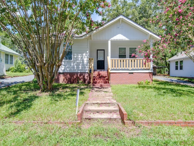 view of front facade with covered porch and a front yard