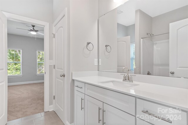 bathroom featuring vanity, ceiling fan, a shower, and tile patterned floors