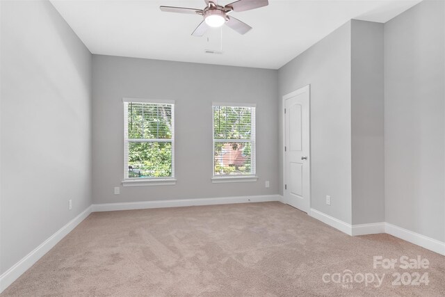 carpeted empty room featuring ceiling fan