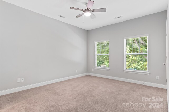 carpeted spare room featuring ceiling fan