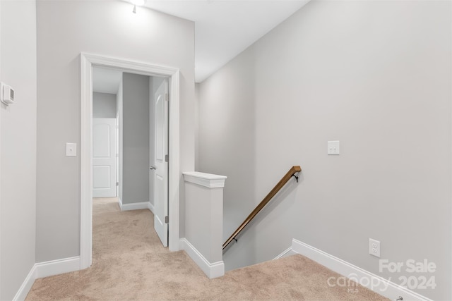 hallway featuring light colored carpet