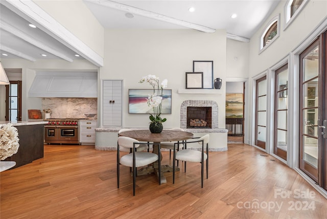 dining area featuring beamed ceiling and light hardwood / wood-style floors