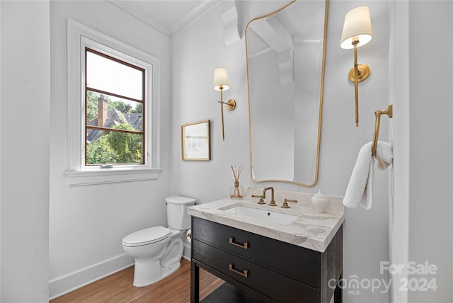 bathroom with ornamental molding, vanity, toilet, and hardwood / wood-style floors