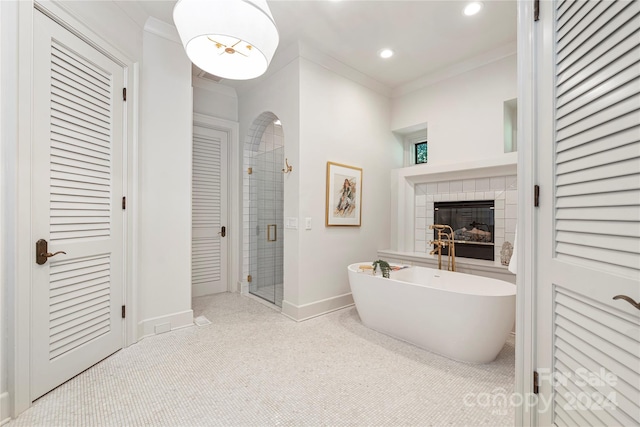 bathroom featuring a tiled fireplace, shower with separate bathtub, and ornamental molding