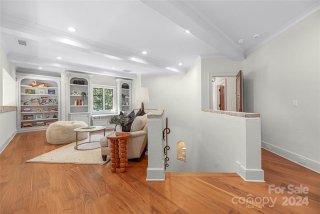 living room featuring crown molding, beamed ceiling, and hardwood / wood-style floors