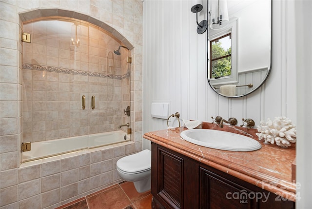 full bathroom featuring tiled shower / bath combo, vanity, toilet, and tile patterned floors