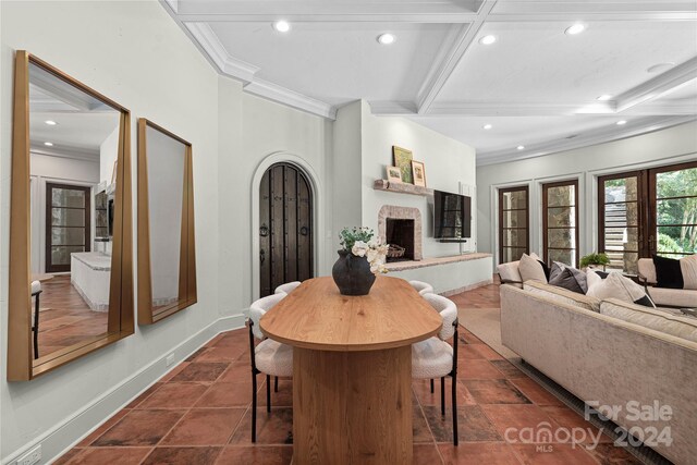 dining space with beamed ceiling and crown molding