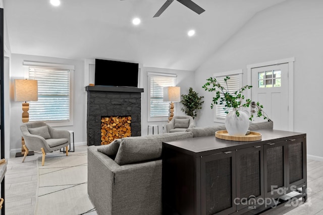 living room with ceiling fan, a fireplace, high vaulted ceiling, and light hardwood / wood-style flooring