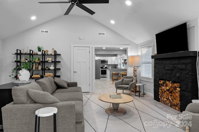 living room with visible vents, a fireplace, ceiling fan, and vaulted ceiling