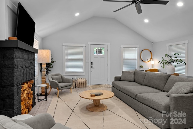 living area featuring recessed lighting, light wood-style floors, a stone fireplace, ceiling fan, and vaulted ceiling