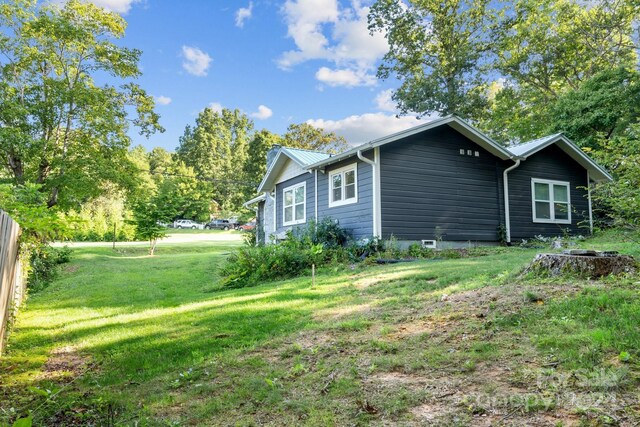 view of home's exterior featuring a lawn and metal roof