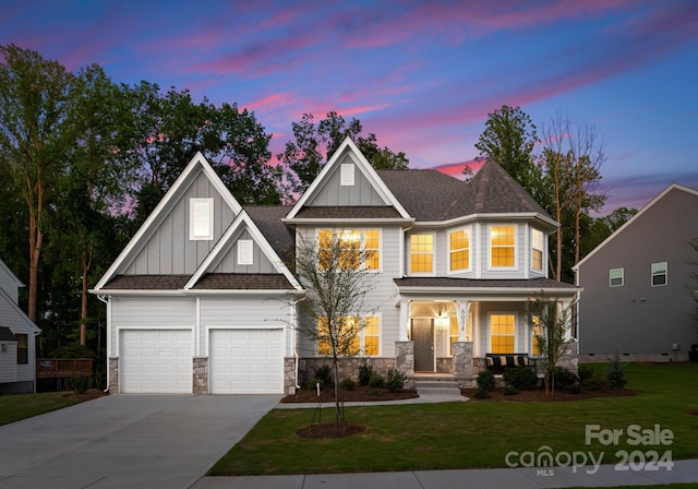 view of front of home featuring concrete driveway, a porch, board and batten siding, and a lawn