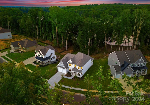 aerial view at dusk featuring a view of trees