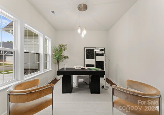 office space featuring baseboards, visible vents, and a chandelier