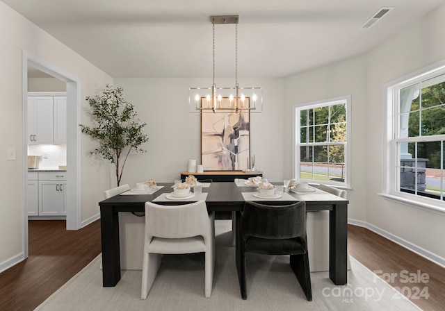 6034 Jepson Ct, Charlotte, NC 28214 - dining area featuring visible vents, baseboards, a notable chandelier, and wood finished floors