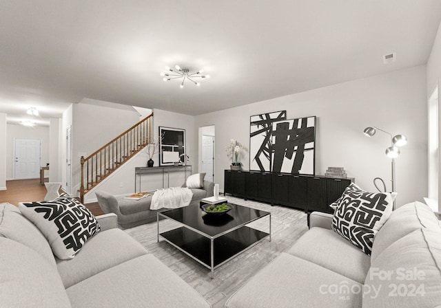 6034 Jepson Ct, Charlotte, NC 28214 - living area featuring stairs, an inviting chandelier, wood finished floors, and visible vents