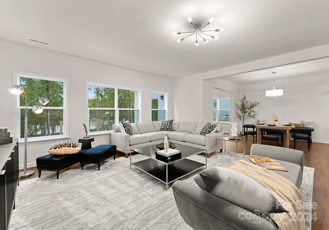 living room with a chandelier, visible vents, light wood-style flooring, and baseboards