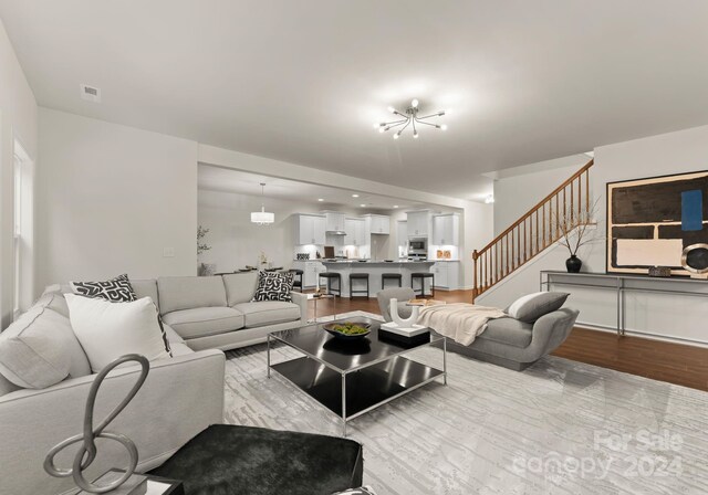 living area featuring stairs, wood finished floors, and visible vents