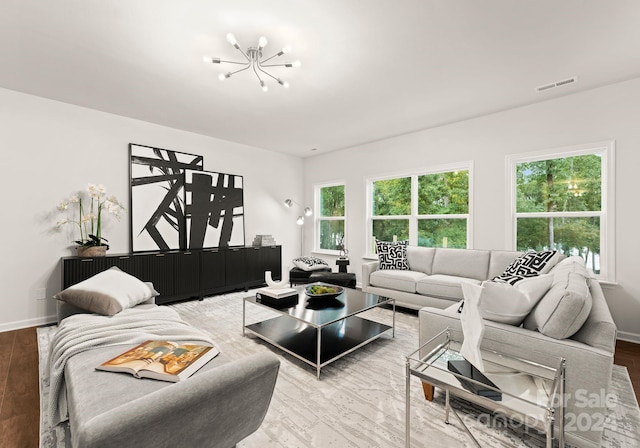 living area featuring visible vents, baseboards, and a notable chandelier