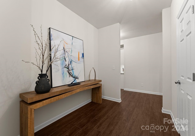 hallway with baseboards and dark wood-type flooring