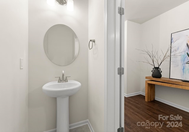 6034 Jepson Ct, Charlotte, NC 28214 - bathroom featuring a sink, baseboards, and wood finished floors