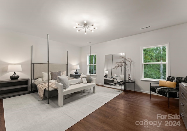 bedroom featuring a chandelier, multiple windows, wood finished floors, and visible vents