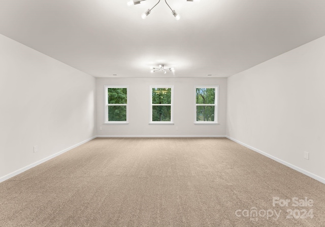 6034 Jepson Ct, Charlotte, NC 28214 - empty room with light colored carpet, an inviting chandelier, and baseboards